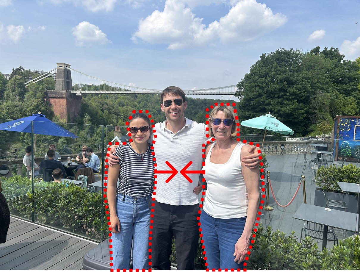 A group photo of three people in front of the Clifton Suspension Bridge, with the person in the middle selected for removal and arrows showing the other two being moved together.
